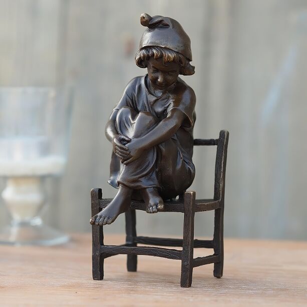 Junge mit Mtze sitzt auf Stuhl - Bronzefigur - Winni