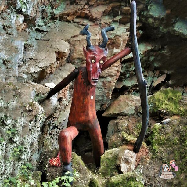 Rot bemalte Teufelfigur aus Holz als Gartendekoration - Teufel